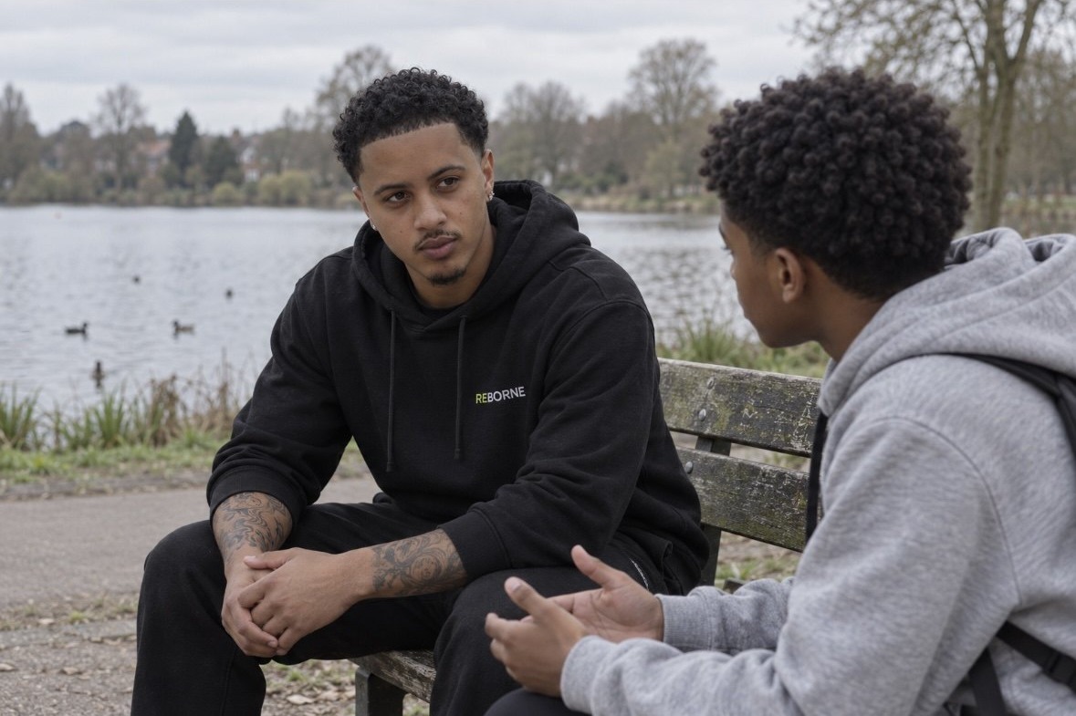 Teo Brown listening to a young person during an outdoor conversation