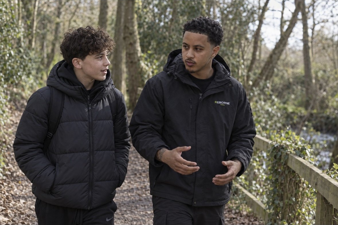 A ReBorne mentor walking and talking with a young person outdoors